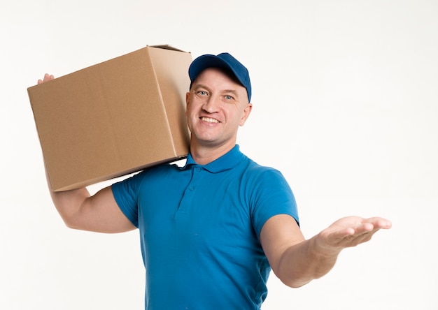 Front view of delivery man carrying cardboard box