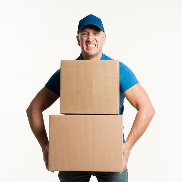 Free photo front view of delivery man holding heavy cardboard boxes