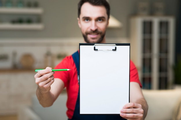 Free photo front view of delivery man showing notepad to sign for order