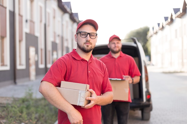 Free photo front view of delivery man with packagaes
