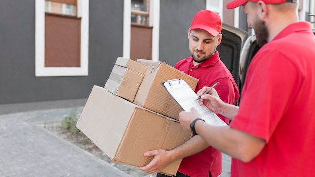 Free photo front view of delivery man with packagaes