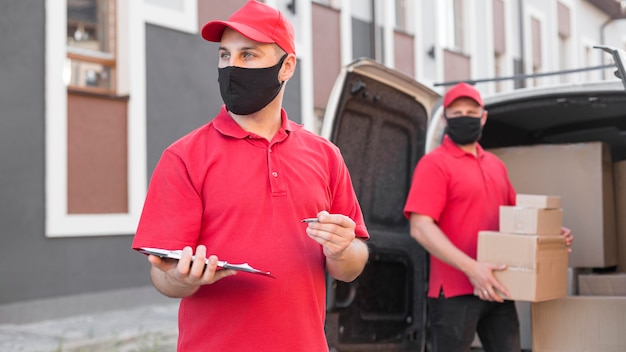 Free photo front view of delivery men with mask