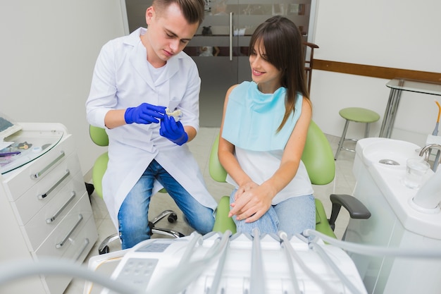 Foto gratuita vista frontale del dentista e del paziente con attrezzatura