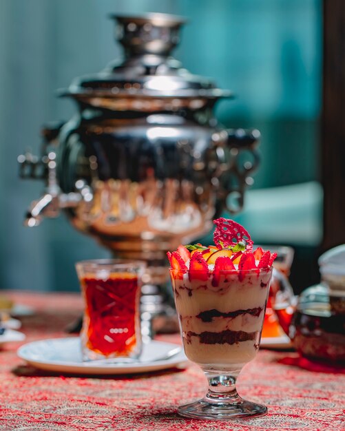 スライスしたイチゴとリンゴとお茶のグラスのガラスの正面デザートティラミス