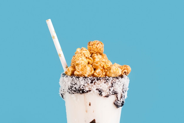 Free photo front view of desserts in jars with popcorn and straw