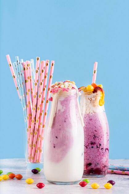 Front view of desserts with gummy worms and straws