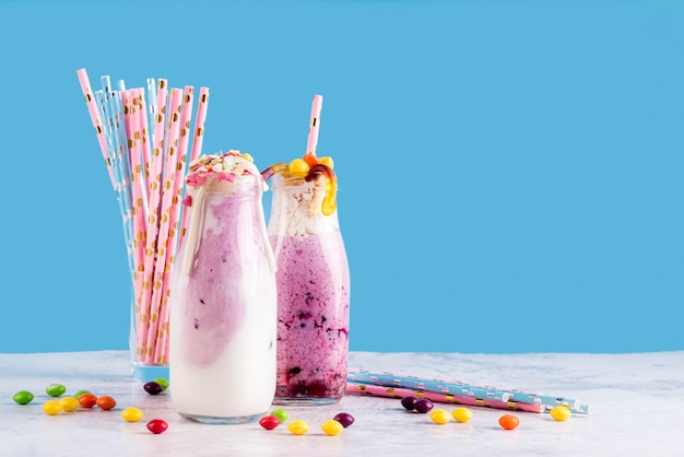 Free photo front view of desserts with straws and gummy worms