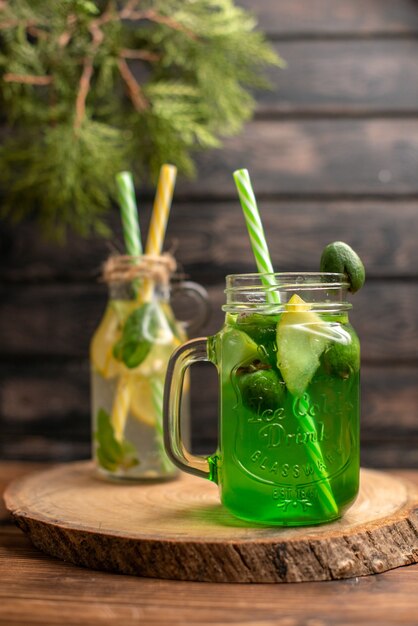 Front view of detox water and fresh juice on brown wooden background