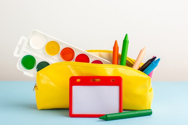 Front view different colorful pencils inside yellow pen box on blue floor