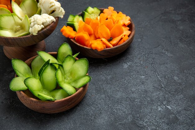 ダークグレーのスペースにある鉢の中のさまざまなデザインの野菜の正面図