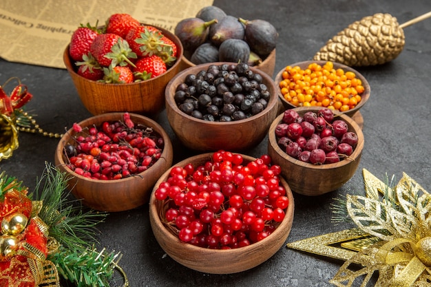 Front view different fresh fruits inside plates on dark background photo mellow many fruit color