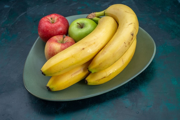 Вид спереди разные фруктовые композиции, яблоки и бананы на темно-синем столе, фрукты, свежие спелые экзотические тропические