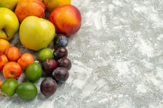 Вид спереди различные фруктовые композиции, свежие фрукты на белом пространстве