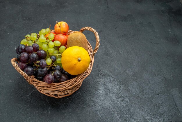 Front view different fruits composition fresh and ripe inside basket on a dark-grey background mellow fresh fruits health ripe