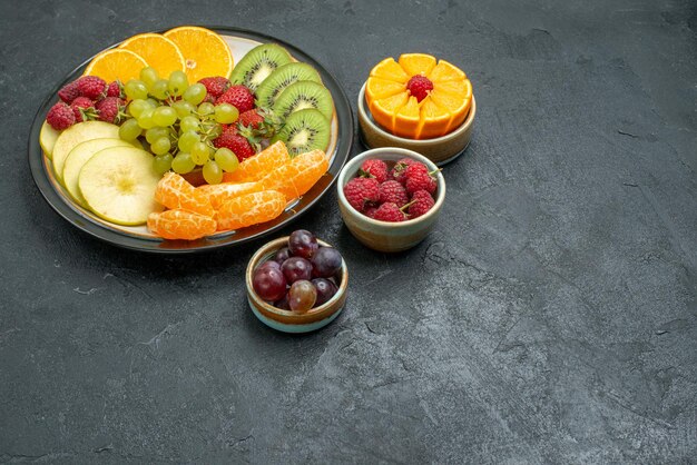 正面図さまざまな果物の組成暗い背景の新鮮なスライスされた果物健康新鮮な熟した果物まろやか