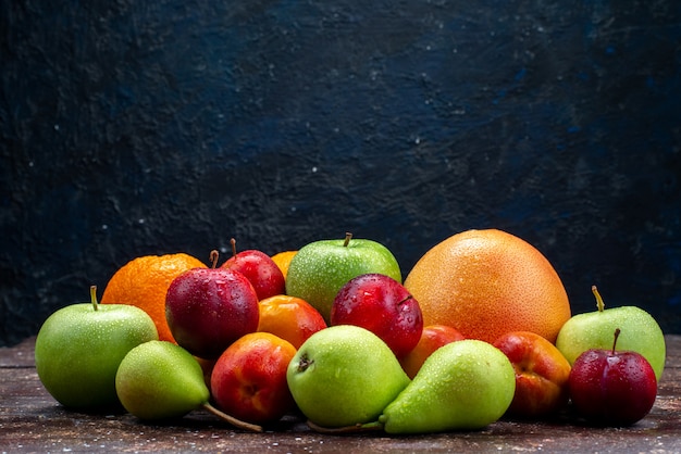 正面のさまざまな果物、新鮮なリンゴ、梨、梅、オレンジ、暗い背景、果物、組成、虹色