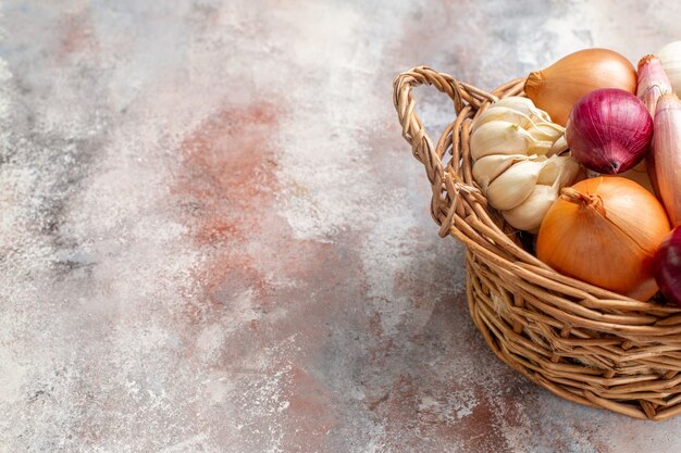 Front view different ingredients onions and garlic inside basket