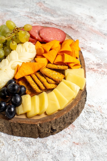 正面図さまざまなスナックcipsソーセージチーズと白いスペースに新鮮なブドウ