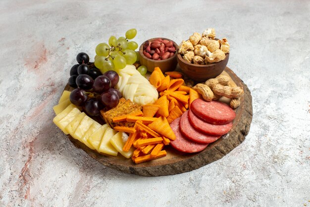 Front view different snacks nuts cips cheese and sausages on white background nut snack meal food