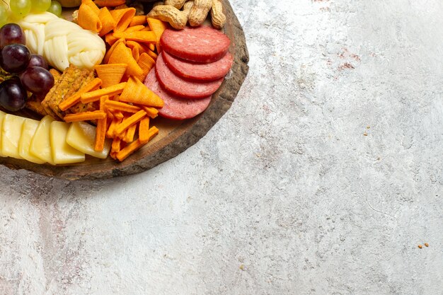 Front view different snacks nuts cips cheese and sausages on white background nuts snack meal food