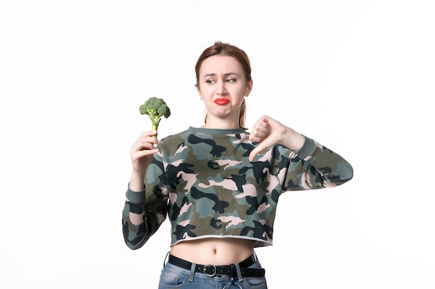 Free photo front view displeased young female holding little broccoli on white