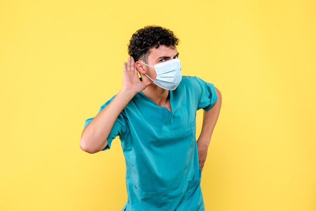 Front view doctor the doctor in mask listens to complaints of patient with coronavirus