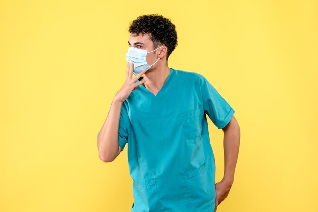 Доктор в маске, вид спереди, говорит, что сейчас многие курильщики заражены коронавирусом