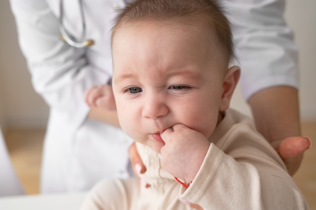 Foto gratuita bambino della holding del medico di vista frontale