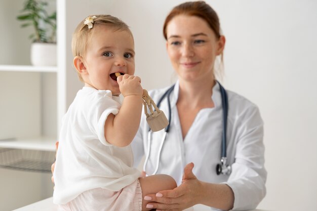 Front view doctor holding baby