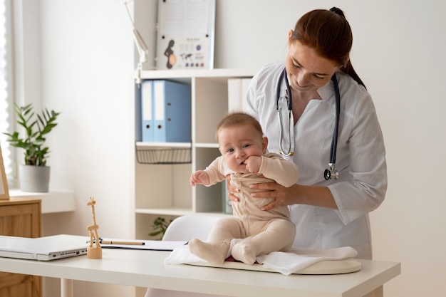 Front view doctor holding cute baby