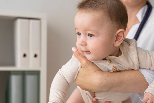 Front view doctor holding cute baby