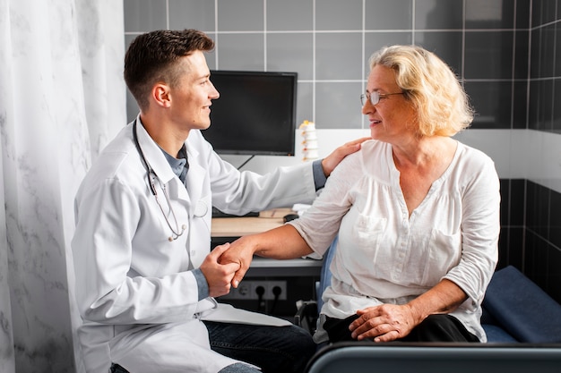 Front view doctor holding patient hand