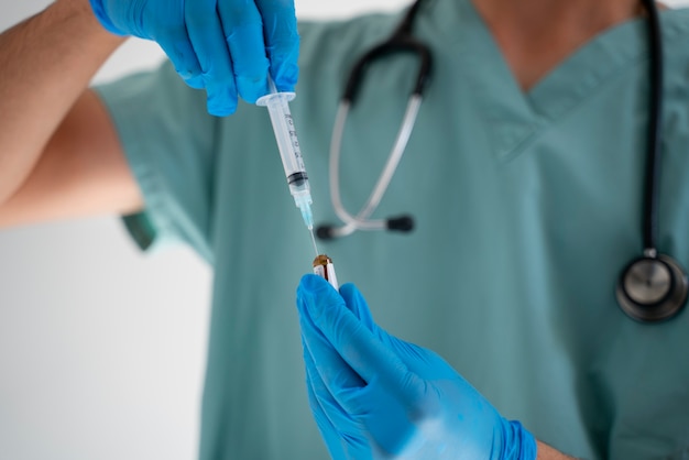 Front view doctor holding syringe and vial