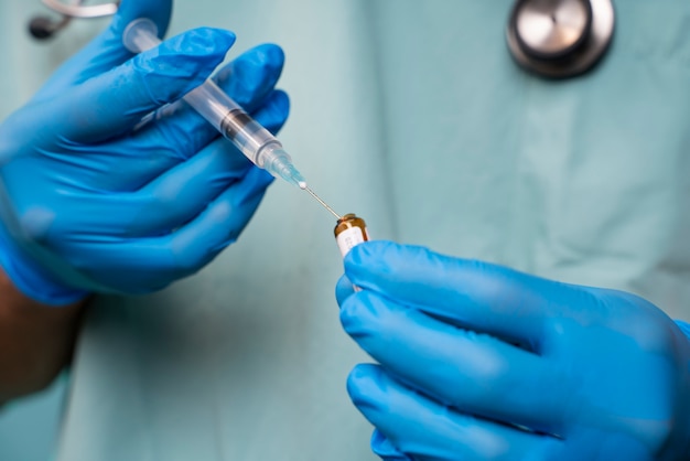 Front view doctor holding syringe and vial