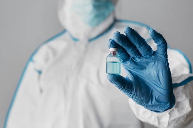 Free photo front view doctor holding a vaccine bottle