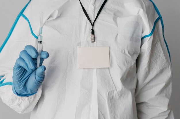 Front view doctor holding a vaccine syringe