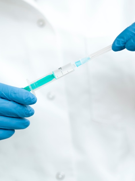 front view of doctor opening up syringe