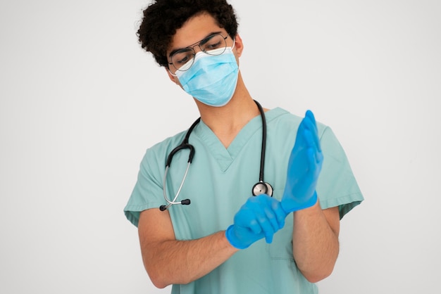 Front view doctor putting on gloves