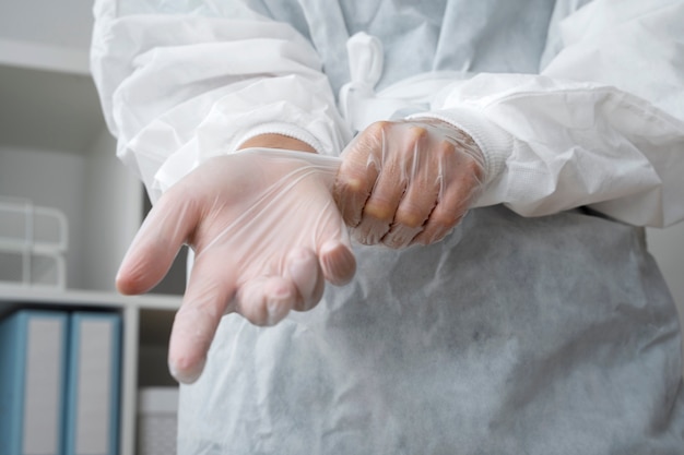 Free photo front view doctor putting on gloves