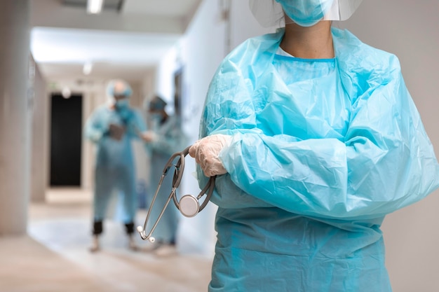 Front view doctor wearing protective wear in the hospital