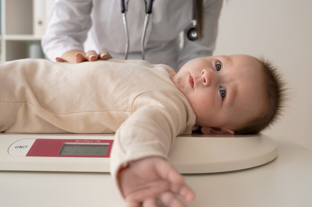 front view doctor weighing baby