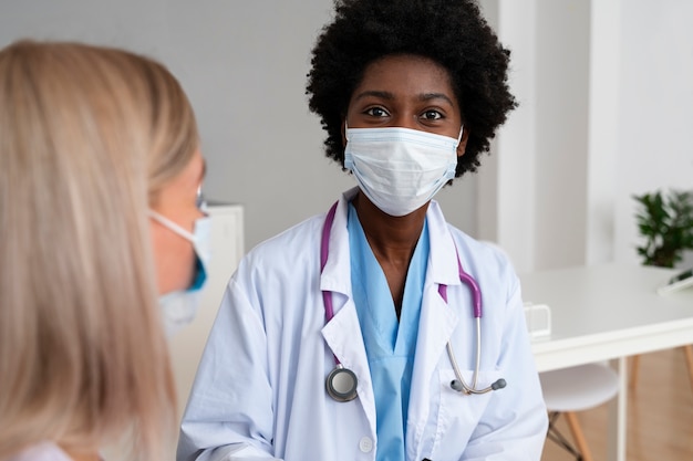 Front view doctor with face mask at clinic