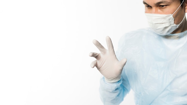 手術用手袋と医療マスクを持つ医師の正面図