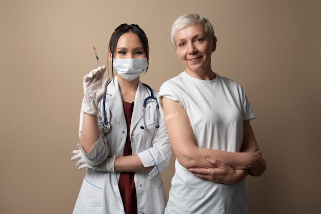 Foto gratuita posa della donna e del medico di vista frontale