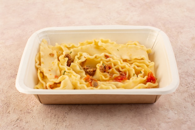 A front view dough meal with tomatoes and meat inside white bowl on pink