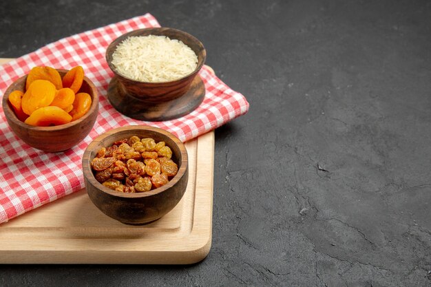 Front view dried apricots with raisins and rice on grey surface fruit dry raisin