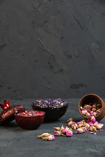 Front view dry pink roses scattered from a jar with purple dried flowers in a vase