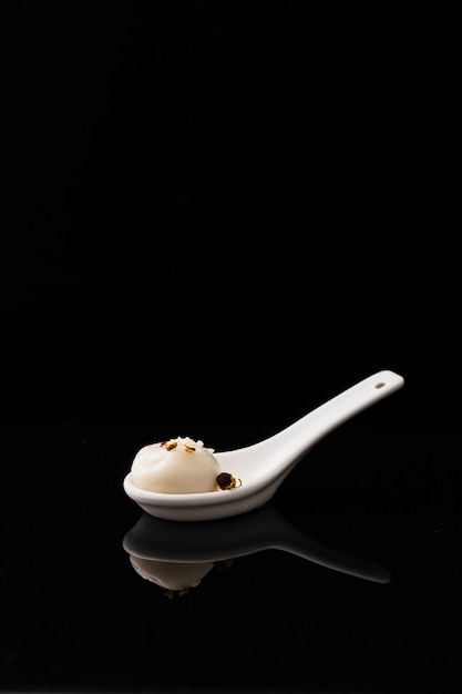 Front view of dumpling with spice in spoon and copy space