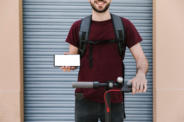 Foto gratuita pilota e-scooter per la vista frontale con smartphone mockup