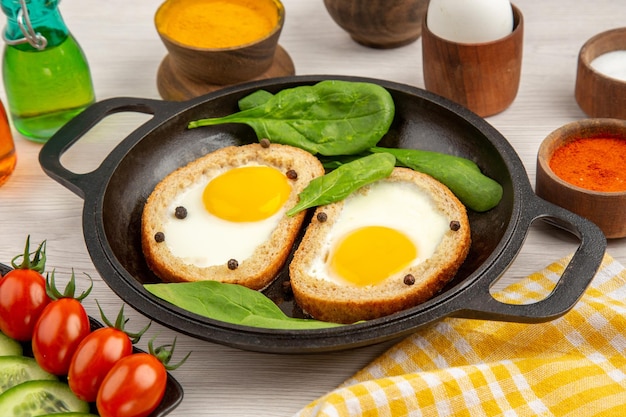 Front view egg toasts with seasonings and sliced cucumbers on white background meal color breakfast lunch dish bread tea